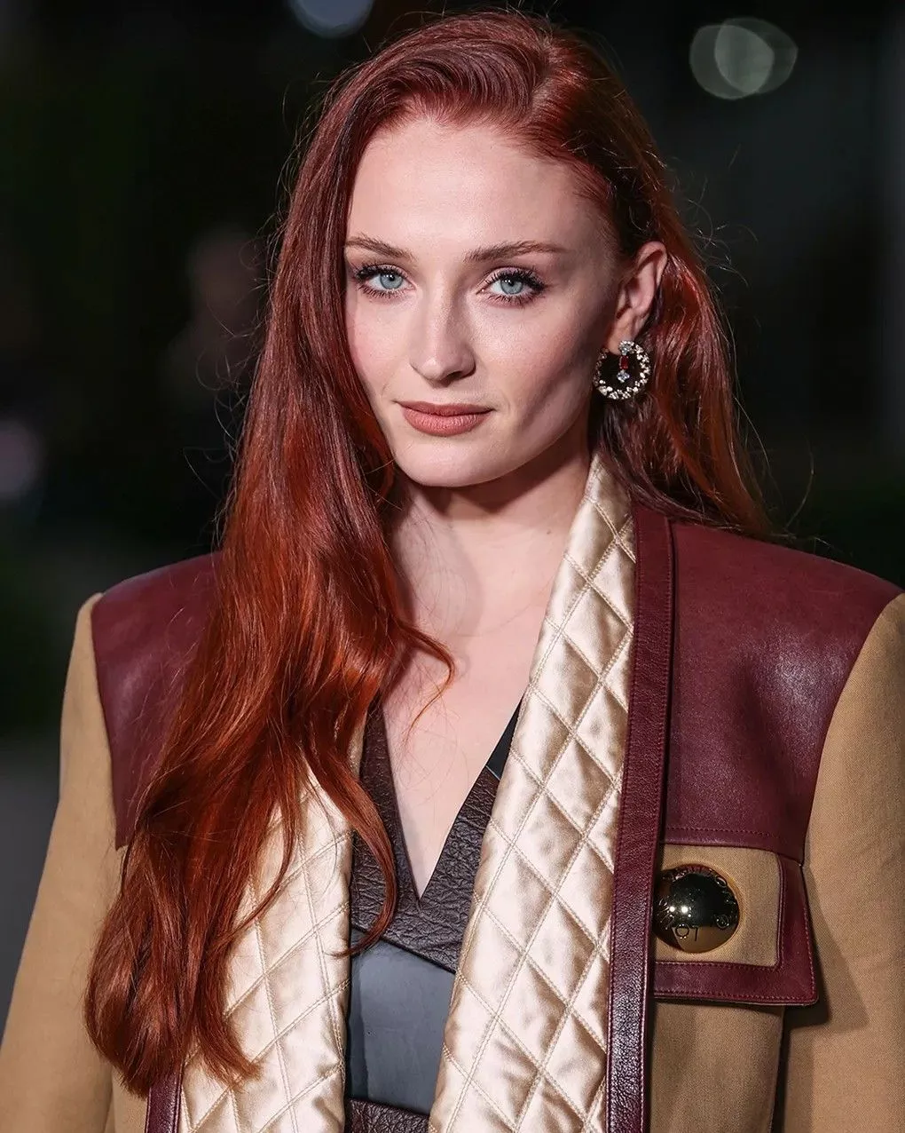 Sophie Turner nosząca jasną miedzianą fryzurę w gładkim prostym looku