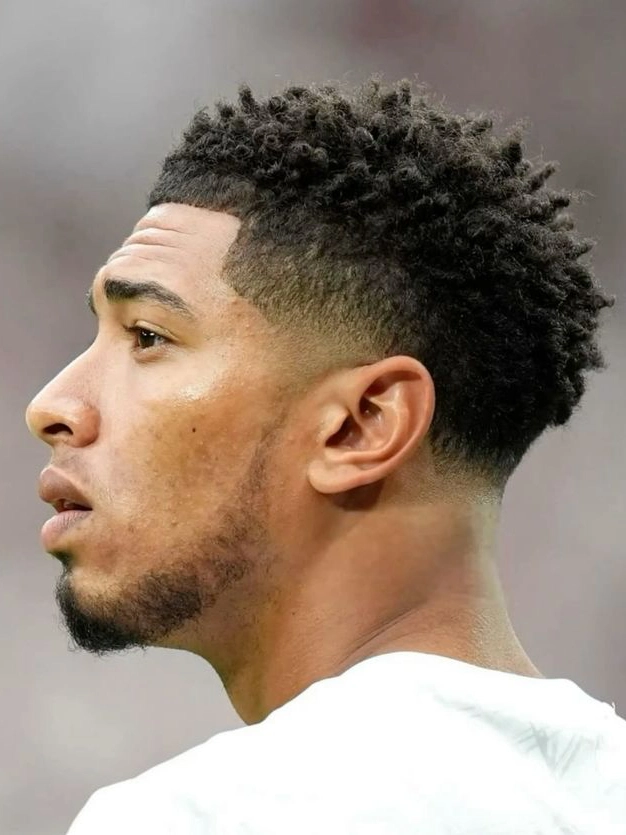 Afro low taper fade celebrujące naturalne loki z zdefiniowanymi krawędziami