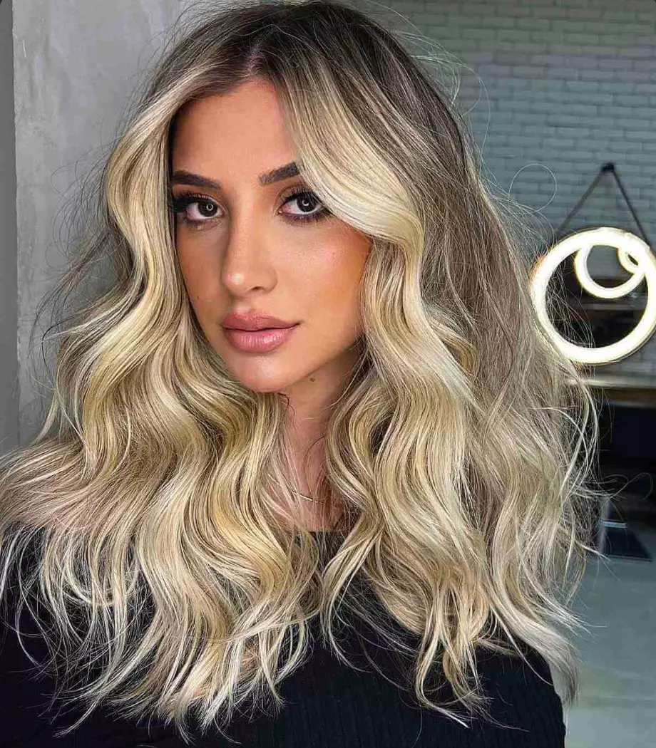 Dramatic Balayage with high contrast, featuring very bright blonde highlights against dark roots
