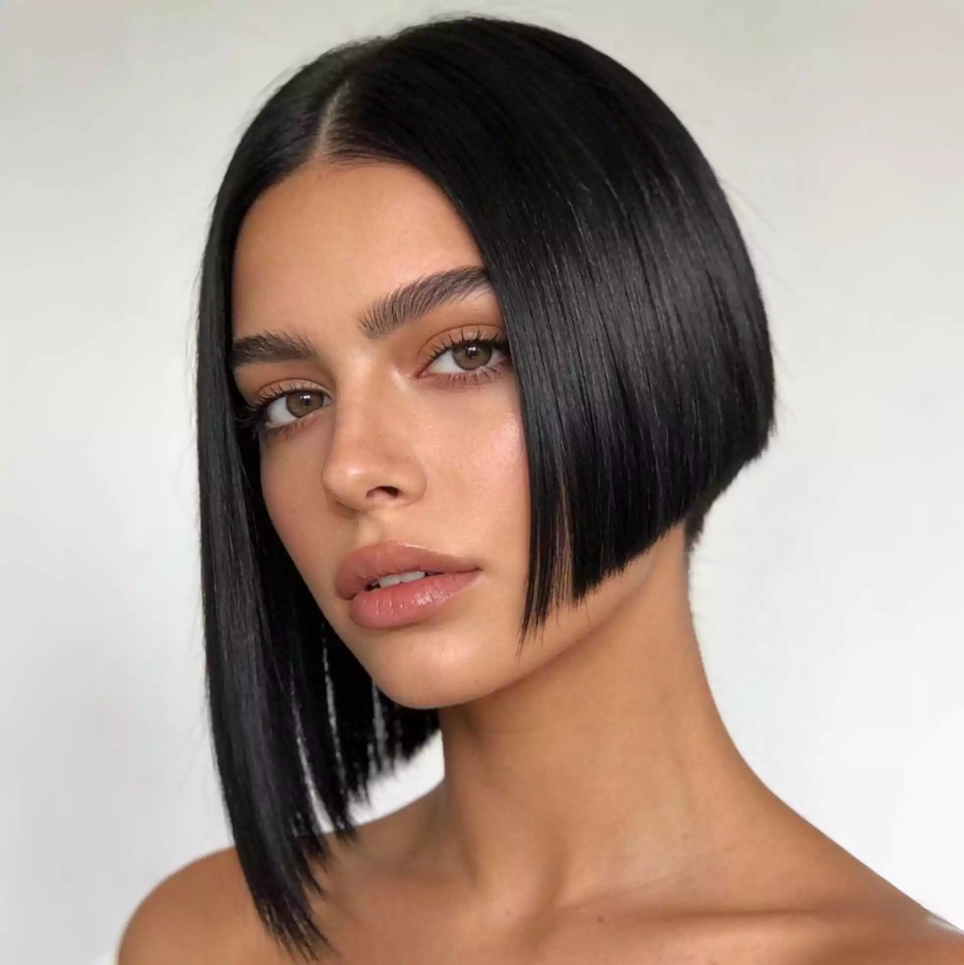 Asymmetrical blunt bob haircut with one side longer and a blunt perimeter