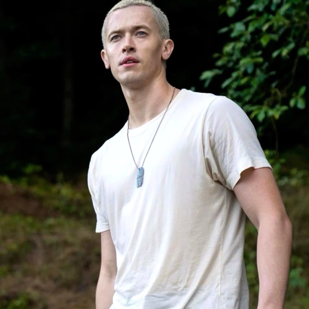 Tom Blyth Hunger Games prequel buzz cut Peacekeeper uniform close-up cinematic character transformation uniform short burr style