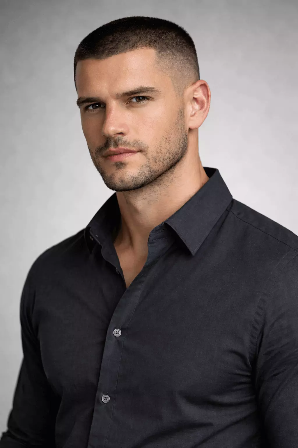 Mature man in his 30s with high and tight buzz cut plus well-groomed short beard, strong jawline, wearing button-up shirt, serious professional expression, studio lighting, realistic portrait