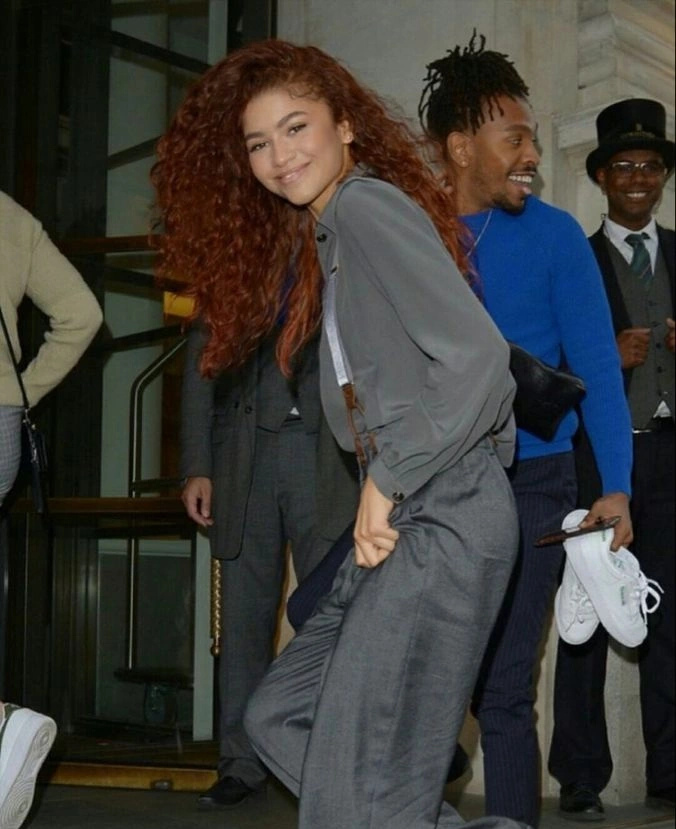 Zendaya with deep copper hair styled in voluminous waves on the red carpet