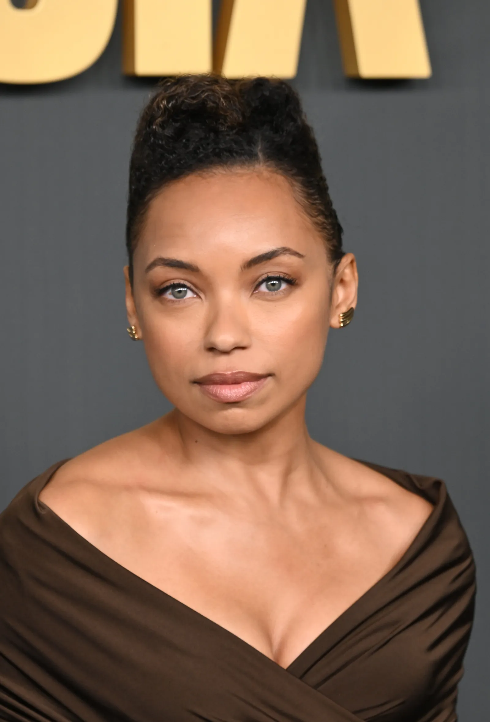 Logan Browning's short curly hairstyle, with slicked sides and a curly top