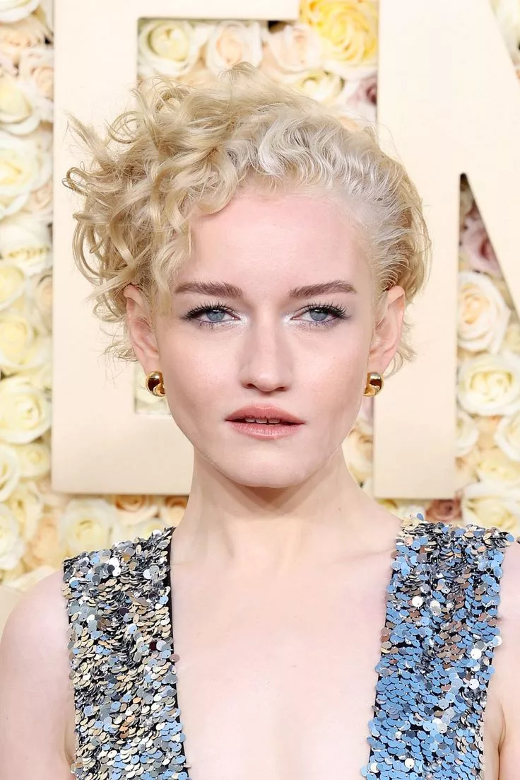 Julia Garner with a deep side part curly hair