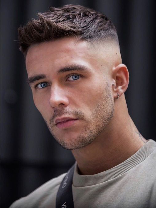 Skin fade haircut featuring a clean shave on the sides fading into longer top hair.