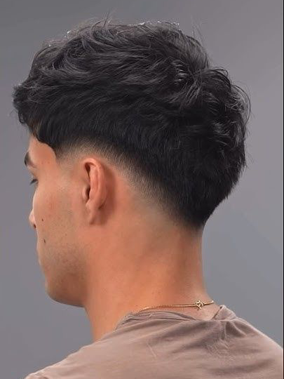 Drop fade haircut with a curved fade line dropping behind the ears and down the back of the head.