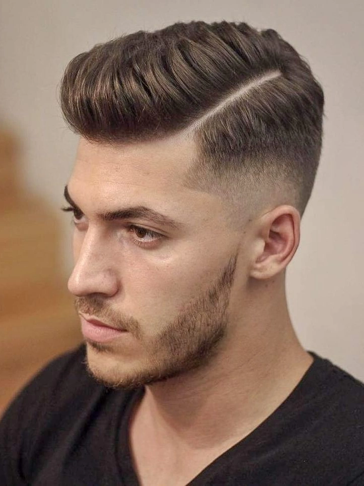 Sharp hard part low taper fade under natural light - professional haircut